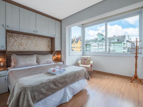 um quarto com uma cama e uma grande janela em Fascino 302 - Apartamento 600 metros Rua Coberta de Gramado em Gramado