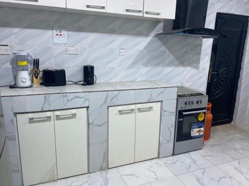 uma cozinha com bancadas em mármore e um fogão em Deoyem Place em Ikorodu