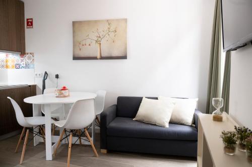 een woonkamer met een blauwe bank en een tafel bij Oporto Mi House in Porto