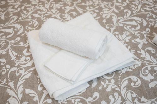 een stapel witte handdoeken zittend op een bed bij Oporto Mi House in Porto