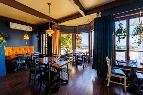 a dining room with tables and chairs and windows at Auberge La Marmite in La Malbaie