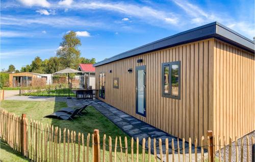 a small building with a fence next to a yard at Stunning Home In Heinkenszand With Wifi in Heinkensand