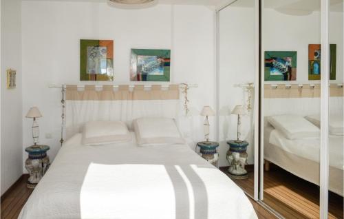 a white bedroom with a bed and a mirror at 4 Bedroom Stunning Home In Fouras in Fouras