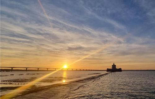 a sunset over a pier with a lighthouse and a bridge at 4 Bedroom Stunning Home In Fouras in Fouras