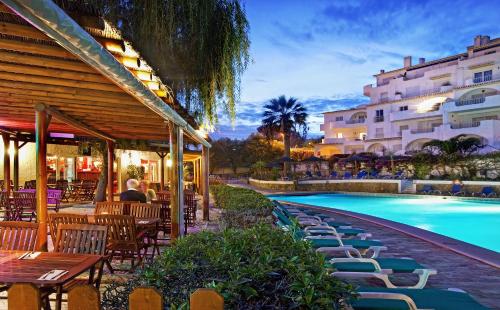 a resort with a swimming pool and tables and chairs at Luz Ocean Club Apartments in Luz