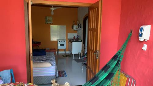 a room with a red wall with a hammock in it at CHALÉS DO GIBA in Maresias