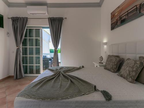 een slaapkamer met een bed met een deken erop bij Luxury Townhouse Vila Rafaella2 n/ São Rafael Beach Albufeira in Albufeira