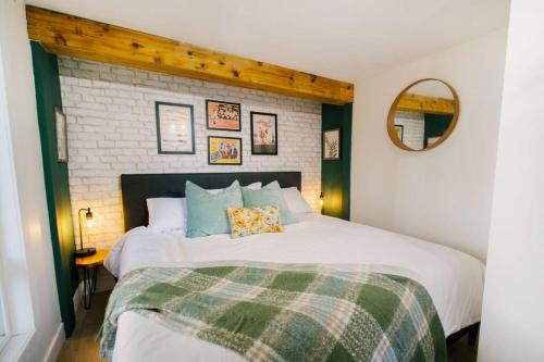 Un dormitorio con una gran cama blanca y una pared de ladrillo en King Garden Suite/20 mins to Dwntwn Vancouvr/PetOk, en North Vancouver