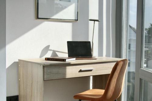 a desk with a laptop computer on it with a chair at The Manhattan A Boutique Hotel By American Ease in Gravenwerth