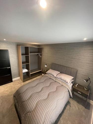 a bedroom with a large bed and a television at Castle St Mews of Southport - 2 bed townhouse in Southport