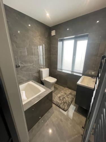 a bathroom with a tub and a toilet and a sink at Castle St Mews of Southport - 2 bed townhouse in Southport