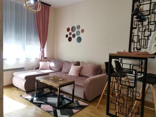 a living room with a couch and a table at Apartman M2 Titova Vila in Palisat
