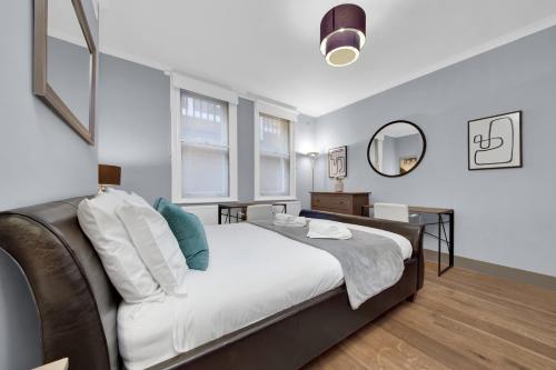 a bedroom with a large bed and a mirror at SERCASA - Cleveland Residence - Fitzrovia in London