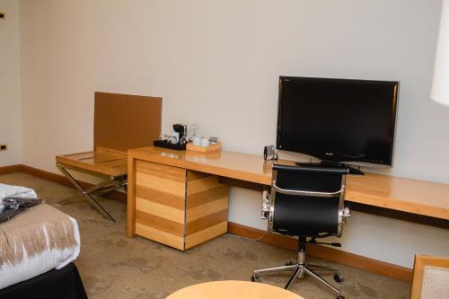 a room with a desk with a television and a bed at Sonesta Hotel Osorno in Osorno
