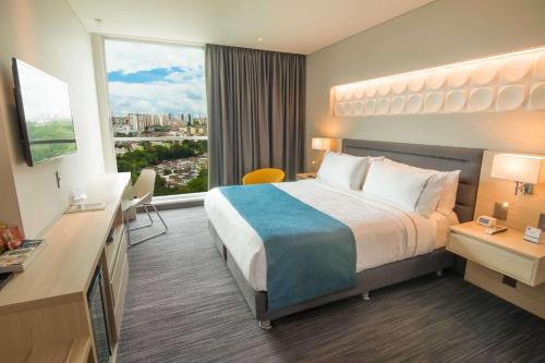 a hotel room with a bed and a large window at Sonesta Hotel Bucaramanga in Bucaramanga