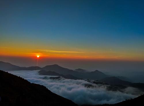 a view of the sun rising above the clouds at sunset at Radisson Blu Resort Visakhapatnam in Visakhapatnam