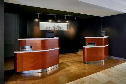 a lobby with two wooden counters in a room at Sonesta Select Raleigh Durham Airport Morrisville in Morrisville