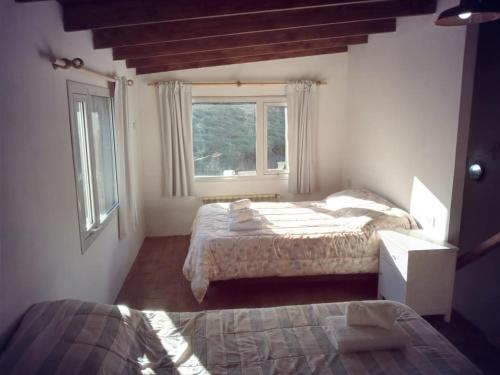 1 dormitorio con 2 camas y ventana en Chaltén Apart 365 en El Chaltén