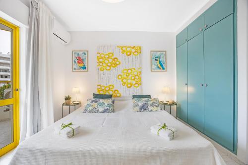 1 dormitorio con 1 cama blanca grande y armarios azules en Casa Gaivota, en Portimão