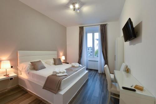 una camera con un grande letto bianco e una scrivania di Le Stanze di Elisa a Roma