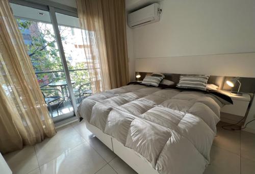 a bedroom with a large bed and a large window at Wehome Buenos Aires in Buenos Aires
