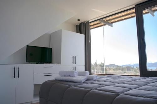um quarto com uma cama grande e uma televisão de ecrã plano em V&P Apt em San Carlos de Bariloche