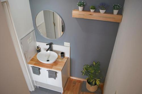W łazience znajduje się umywalka i lustro. w obiekcie V&P Apt w mieście Bariloche