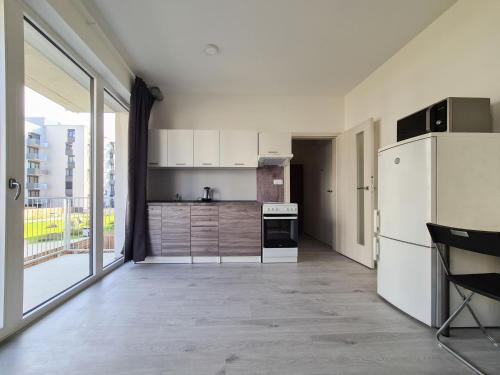 kuchnia z białą lodówką i dużym oknem w obiekcie Cozy and modern apartment near Brno city center w mieście Husovice