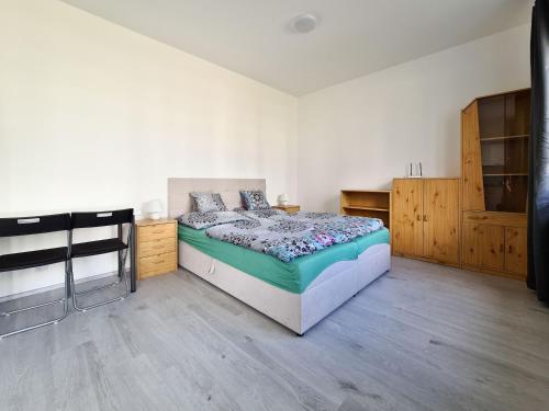 a bedroom with a bed and a wooden floor at Cozy and modern apartment near Brno city center in Husovice