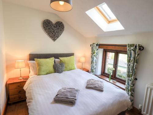 a bedroom with a bed with two towels on it at Gowan Cottage in Staveley