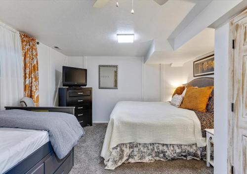 um quarto com duas camas e uma televisão em Heart of Orem Basement 3 bedroom Apartment w/ Waffles. em Orem