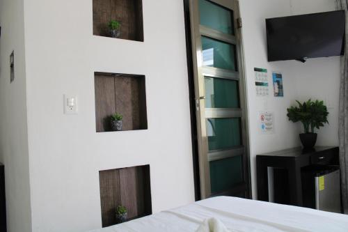 1 dormitorio con 2 ventanas con plantas. en Casa Zazil, en Bacalar