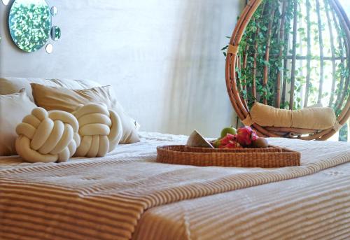 a bed with a basket of fruit on it at Heart & Soul PH Suite Tulum in Tulum