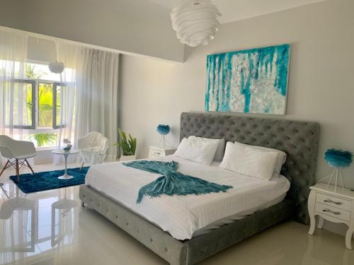 a bedroom with a bed with a blue painting on the wall at Sea Winds with Direct Ocean Views in Cabarete