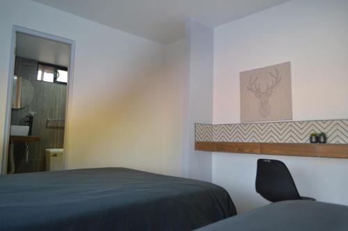 1 dormitorio con 1 cama y 1 silla en APARTAMENTOS AMBASSADOR, en Tijuana