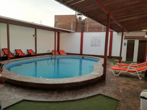 a large swimming pool with chairs around it at Hospedaje Fremiott in Huanchaco
