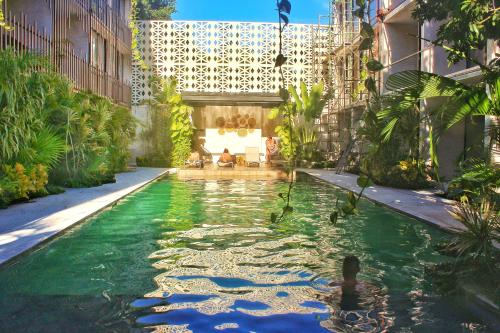 a pool in the middle of a building with green water at Heart & Soul PH Suite Tulum in Tulum