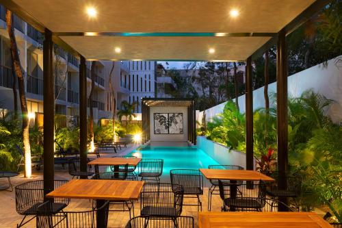 an outdoor patio with tables and a swimming pool at Modern Studio Pool Access Near Downtown A105 in Tulum