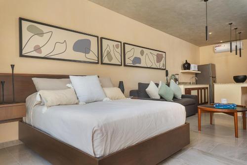 a bedroom with a large bed and a couch at Modern Studio Pool Access Near Downtown A105 in Tulum