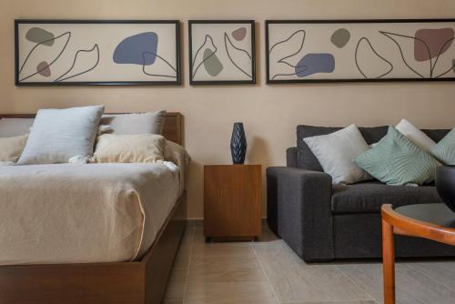 a living room with a bed and a couch at Modern Studio Pool Access Near Downtown A105 in Tulum