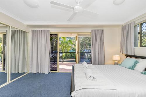 a bedroom with a large bed and sliding glass doors at 4/84 Lawson Street - Beach Haven 4 in Byron Bay