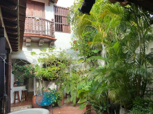 a courtyard of a house with plants and a balcony at Casa Digna in Cartagena de Indias