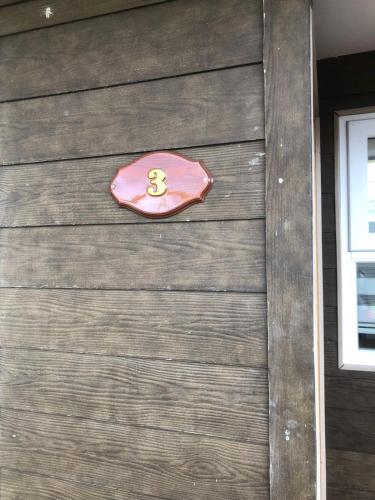 a number sign on the side of a garage at Cabañas Carrera in Punta Arenas