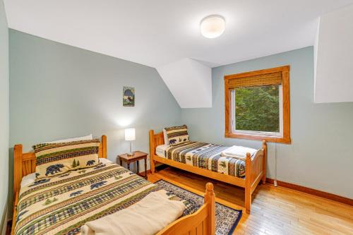 a bedroom with two beds and a window at Cozy Cabin in the Woods in Londonderry