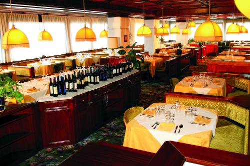 a dining room with tables and wine bottles at Hotel Corona in Val di Zoldo