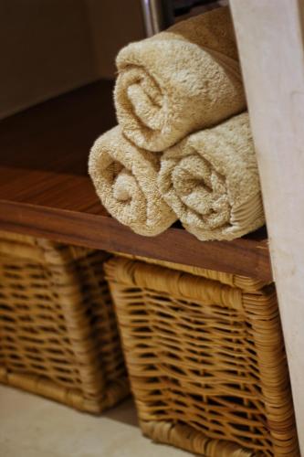 a stack of towels and wicker baskets on a shelf at Heart & Soul PH Suite Tulum in Tulum