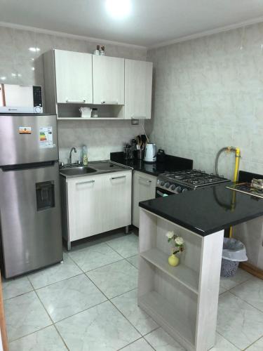 a kitchen with a stainless steel refrigerator and a stove at Cabañas Carrera in Punta Arenas