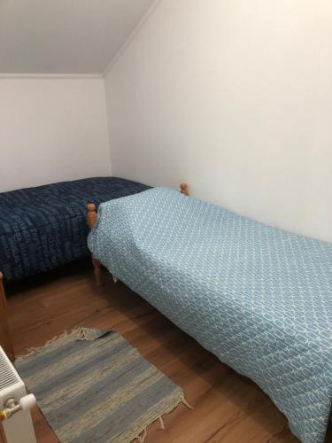 a bedroom with two beds and a rug at Cabañas Carrera in Punta Arenas