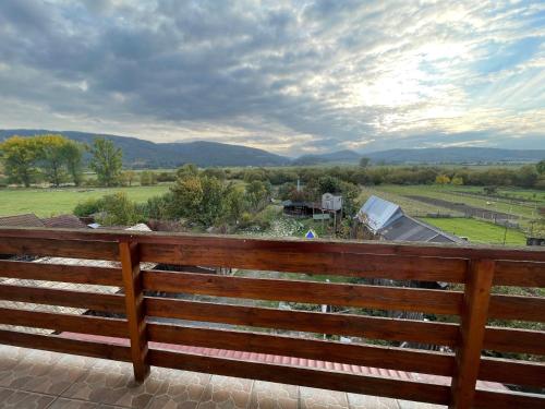 a wooden bench on a patio with a view at Relax Mariánka in Betlanovce