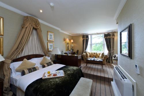 a hotel room with a large bed and a chair at The Colonnade in London
